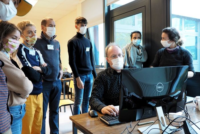 Photo: L'équipe concentrée sur une démonstration de Christophe